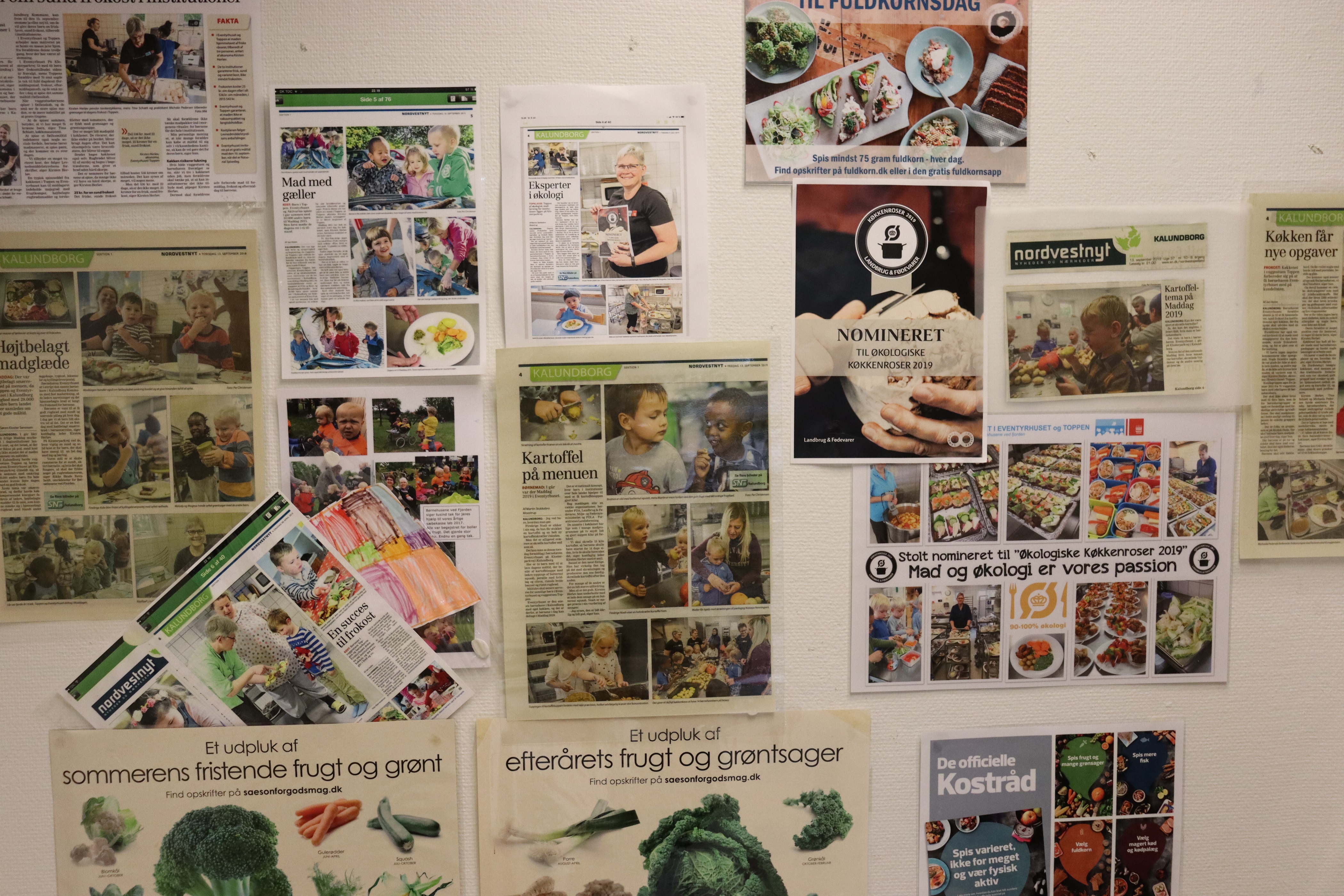 Køkkenets væg med avis artikler med positiv omtale om netop køkkenet
